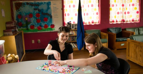Teacher playing board game with student