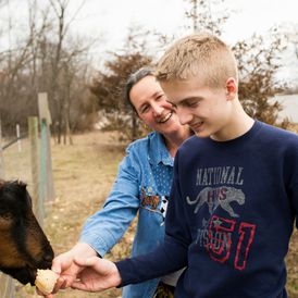 Gus with boy feeding goats